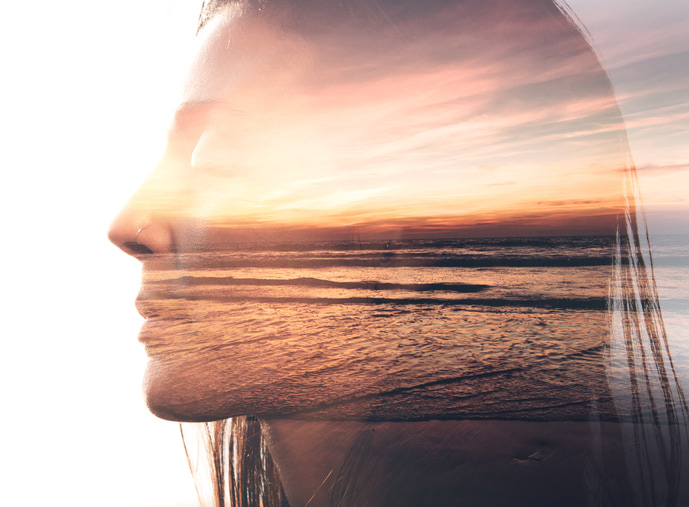 Woman silhoutee over a beach at sunset and the ocean