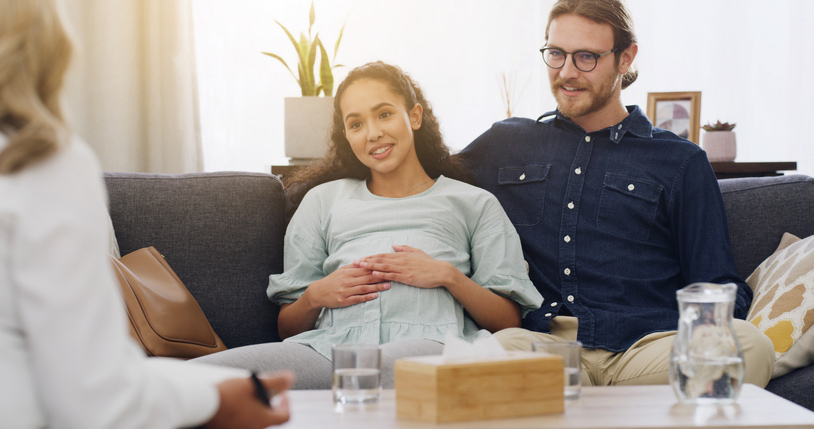 Couple, woman heavily pregnant in a therapy session